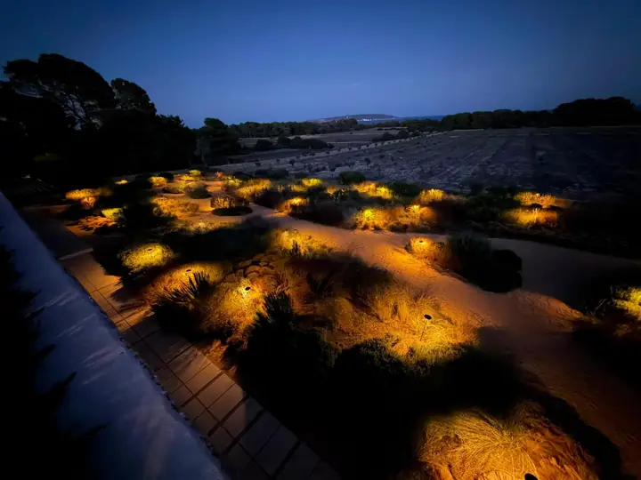 Jardín mediterráneo iluminado con balizas LED al anochecer