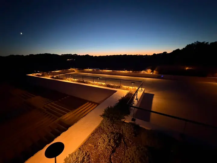 Terraza de villa con iluminación LED en jardineras y barandilla al atardecer