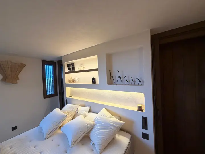 Dormitorio con cabecero de hornacinas iluminadas con LED