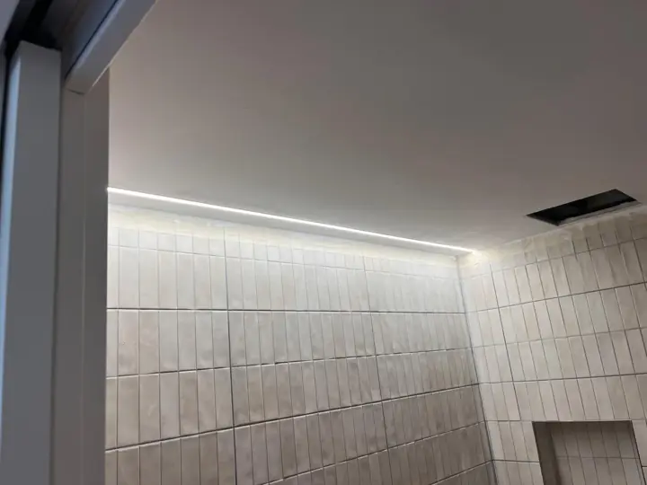 Perfil LED lineal en el techo de un baño